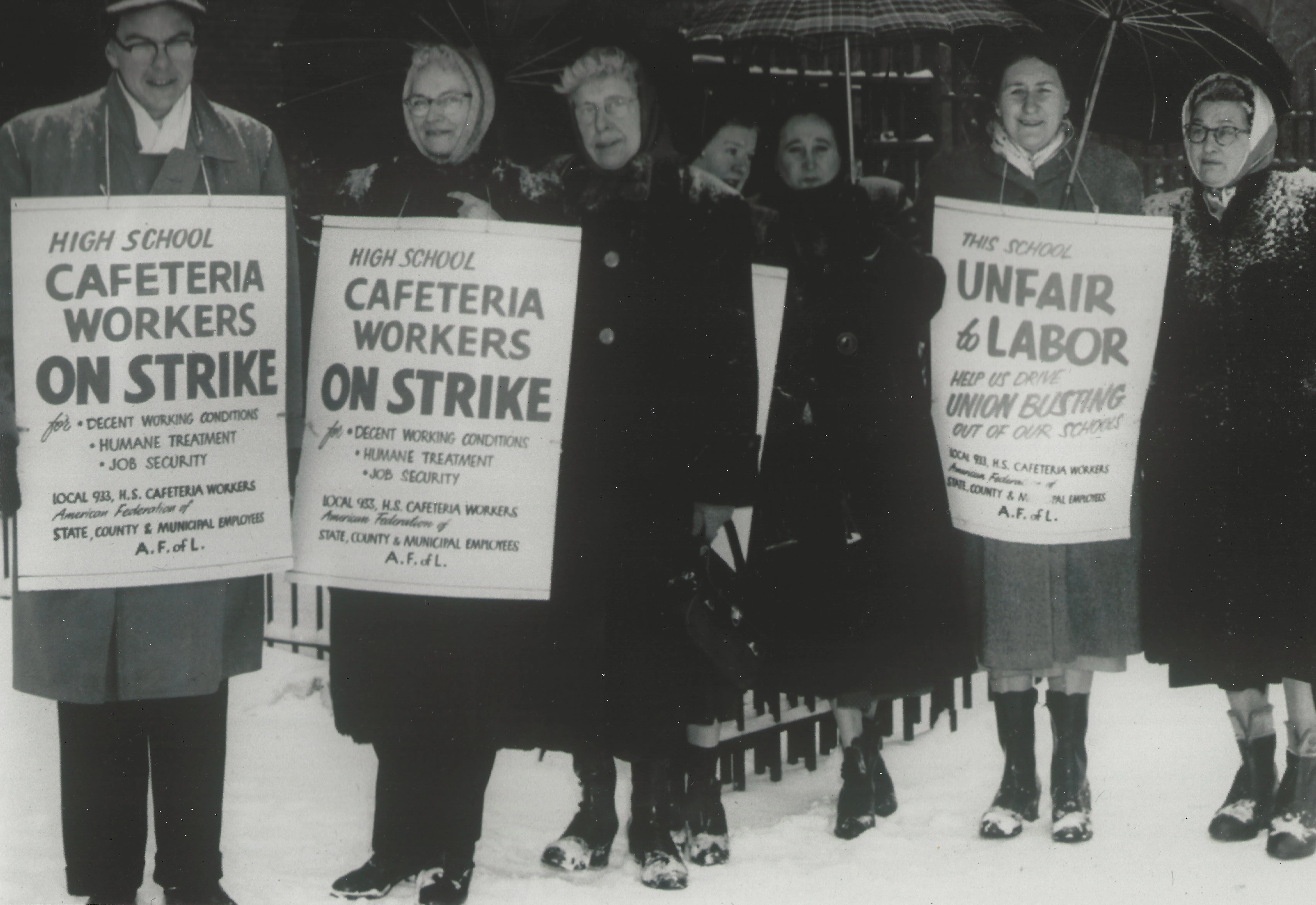 Historical photograph in black and white of striking cafeteria workers with signs